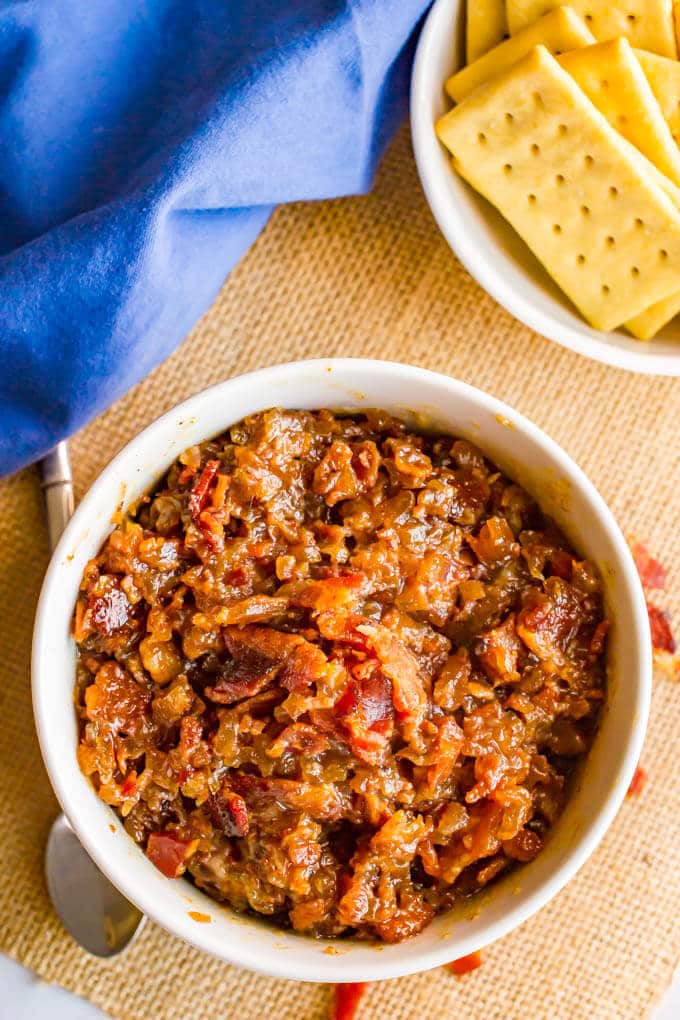 Bacon jam with bourbon served in a white bowl with crackers nearby