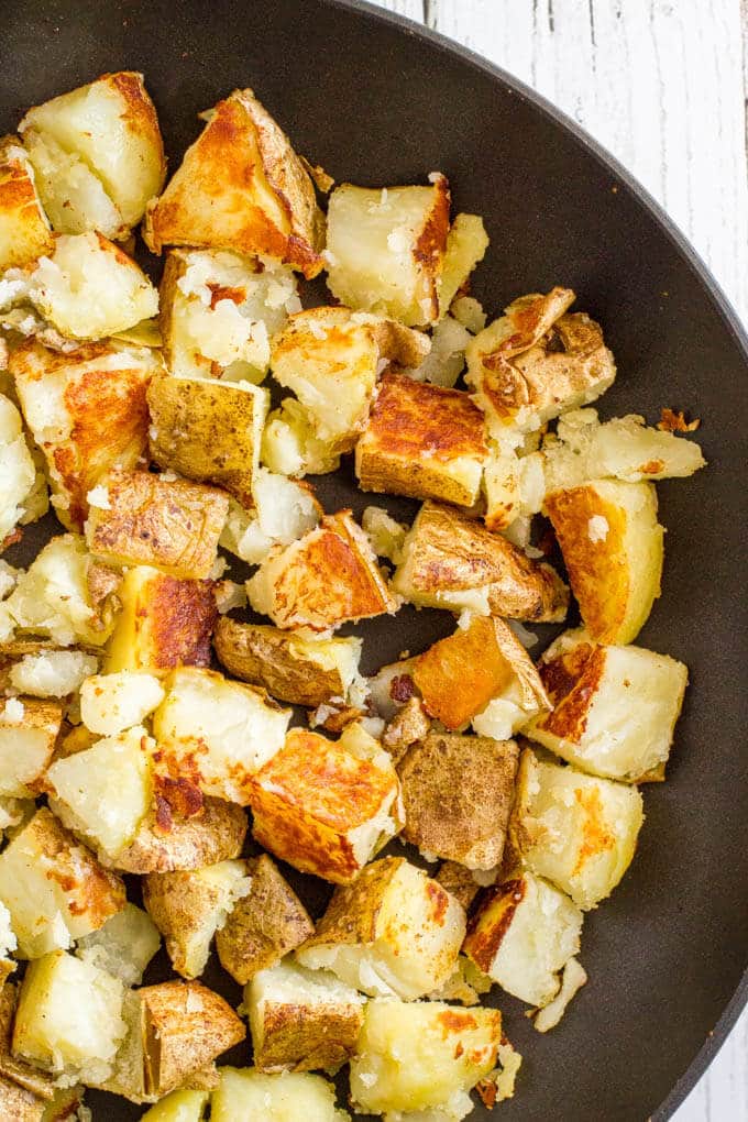 Browned cooked potato pieces in a skillet