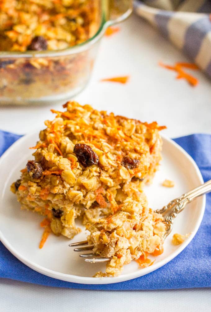 A fork resting with a bite of baked oatmeal on a small round plate.