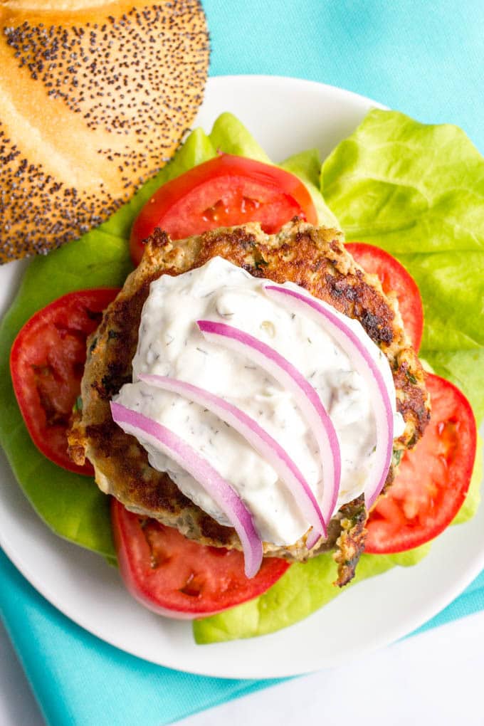 Greek turkey burgers with tzatziki sauce are loaded with spinach, red onion and feta cheese for a delicious but easy taste of Greece! | www.familyfoodonthetable.com
