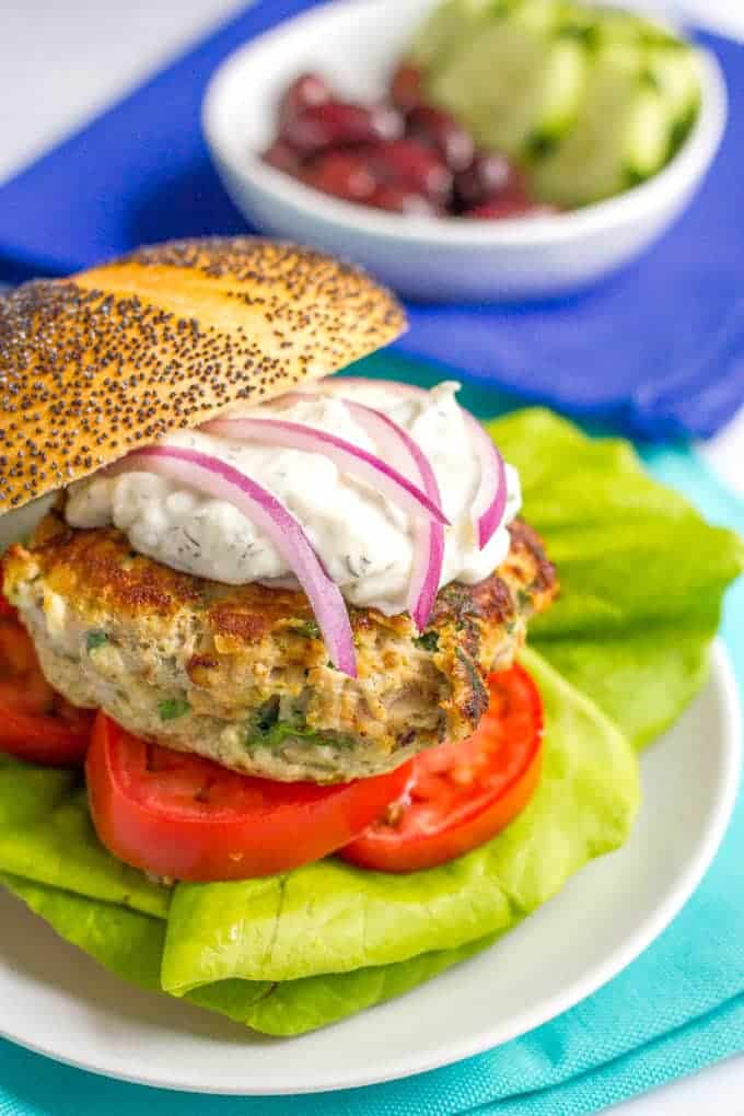 Greek turkey burgers with tzatziki sauce are loaded with spinach, red onion and feta cheese for a delicious but easy taste of Greece! | www.familyfoodonthetable.com