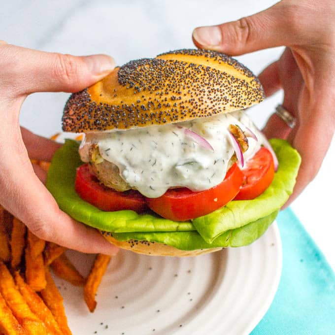 Greek turkey burgers with tzatziki sauce are loaded with spinach, red onion and feta cheese for a delicious but easy taste of Greece! | www.familyfoodonthetable.com