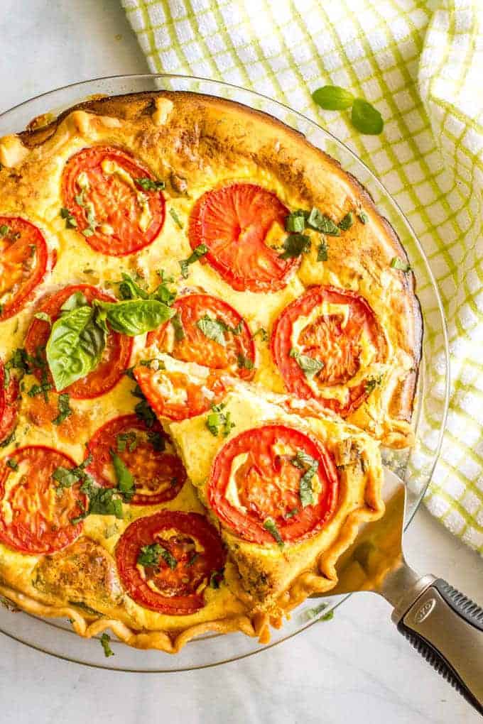 This easy tomato breakfast tart with basil + two cheeses has sliced tomatoes on top for a unique and beautiful brunch presentation - a great recipe for company (and Mother's Day!) #tomatoes #breakfasttart #brunchrecipes #brunch