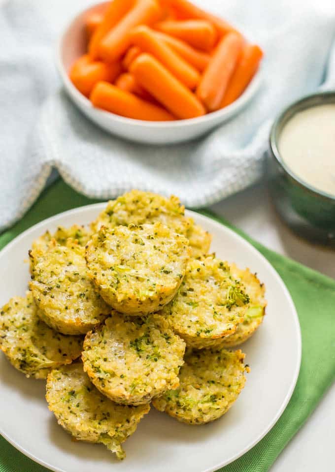 A stack of broccoli cheese quinoa bites on a small white plate set on a green napkin.