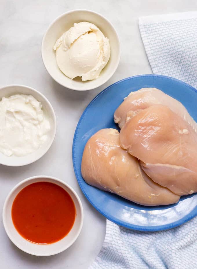 Ingredients in separate bowls and containers laid out for making buffalo chicken