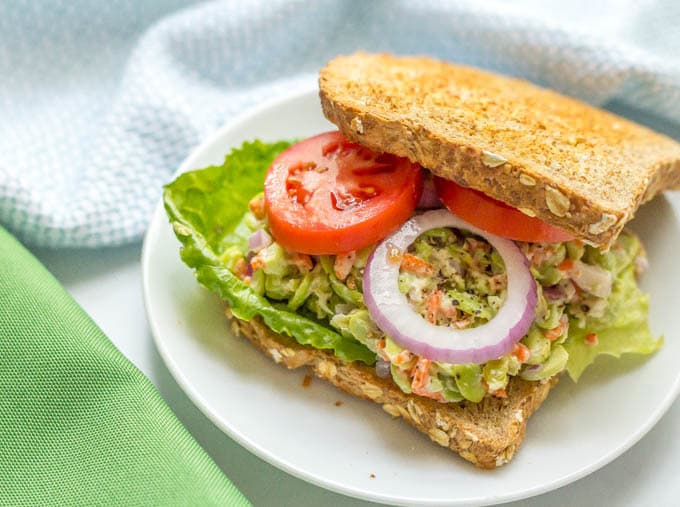 Smashed edamame salad sandwich with tomatoes and red onion