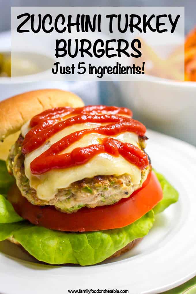 Close up of zucchini turkey burger with melted cheese and ketchup served on a bun with lettuce and tomato