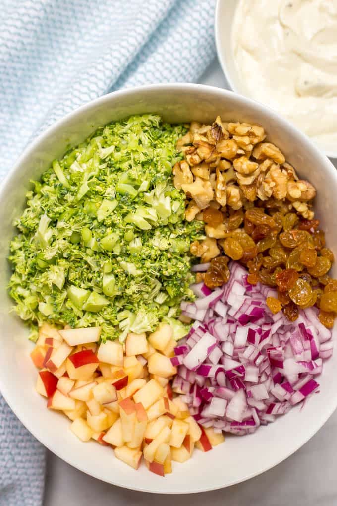 Healthy broccoli apple salad is mixed with walnuts, raisins and a cool, creamy sweet dressing for a delicious side salad that’s perfect for cookouts! #broccoli #summersalads #summerrecipes #potlucks