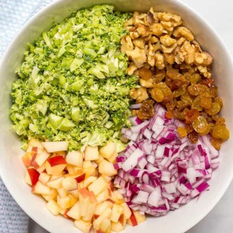 Healthy broccoli apple salad ingredients arranged in bowl