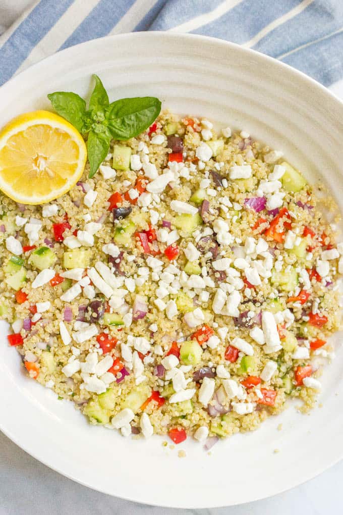 Mediterranean quinoa salad mixed in bowl and topped with feta cheese