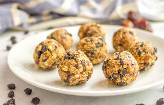 No bake blueberry oatmeal cookie balls on plate with scattered dried blueberries