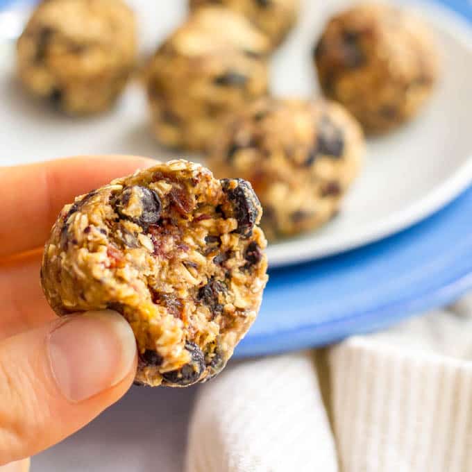 No bake blueberry oatmeal cookie ball held in hand with bite taken