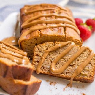 Whole wheat peanut butter banana bread with drizzle of peanut butter over top and on slices