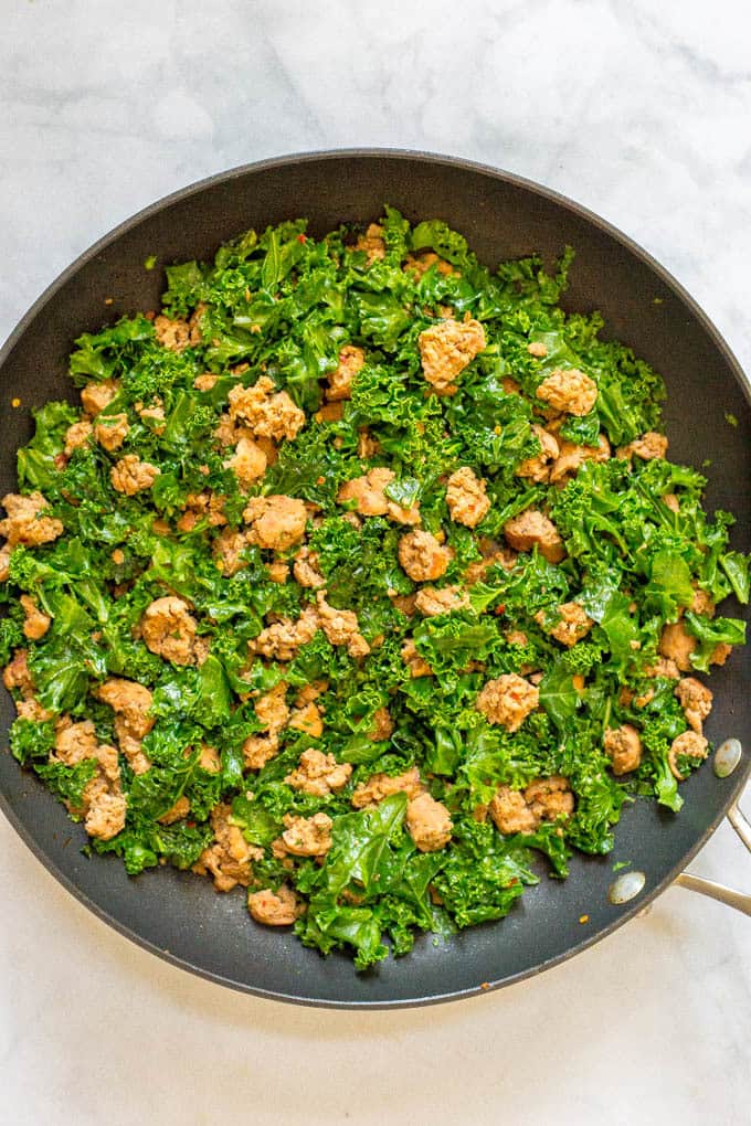Cooked turkey sausage and kale in pan