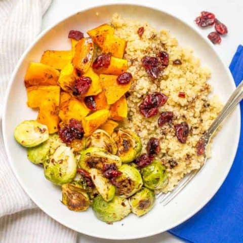 This quinoa bowl with butternut squash and Brussels sprouts is a filling vegetarian dinner that’s topped with dried cranberries and balsamic vinegar for a warm, hearty bowl of delicious! | www.familyfoodonthetable.com