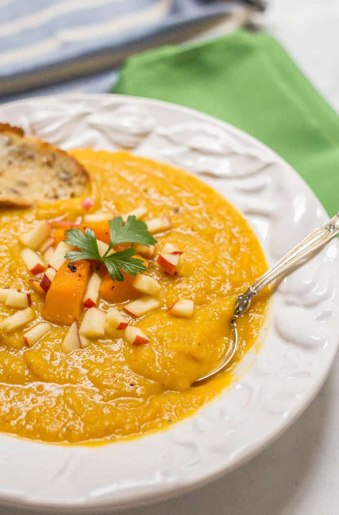 Roasted butternut squash apple soup is perfect for a cozy fall dinner! This soup is thick and filling and has a perfect background of sweetness and warm spices! | www.familyfoodonthetable.com