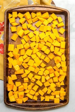 Cubed chunks of butternut squash on roasting pan