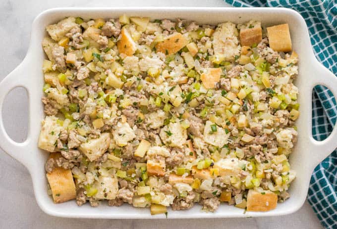 Apple turkey sausage dressing in a white casserole dish before being baked
