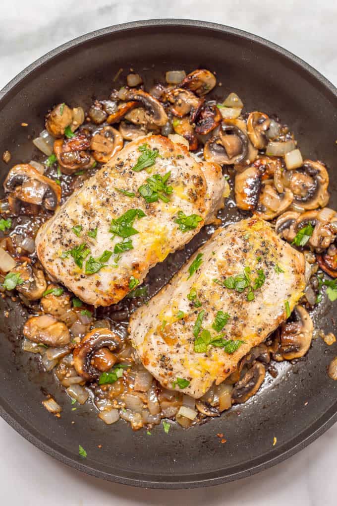 Garlic butter pork chops are an easy one-pan dish with a delicious mushroom-onion mixture and a hint of lemon to brighten all the flavors. Perfect for a weeknight family dinner! | www.familyfoodonthetable.com