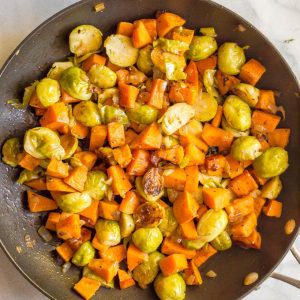 Sautéed sweet potatoes and Brussels sprouts in pan