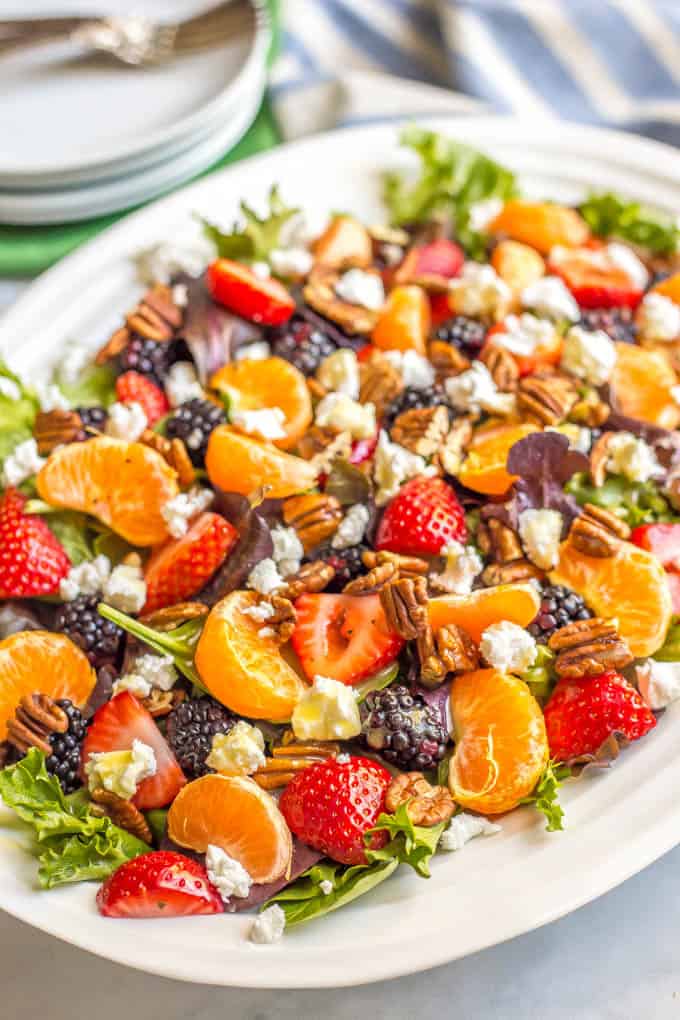 This mixed greens salad with fruit, goat cheese and nuts is perfect for a beautiful side dish or brunch spread! It comes together quickly and is finished with a super easy honey-lime vinaigrette. #easysalad #brunch #vegetarian | www.familyfoodonthetable.com