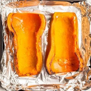 Roasted butternut squash on a sheet pan with middles scooped out