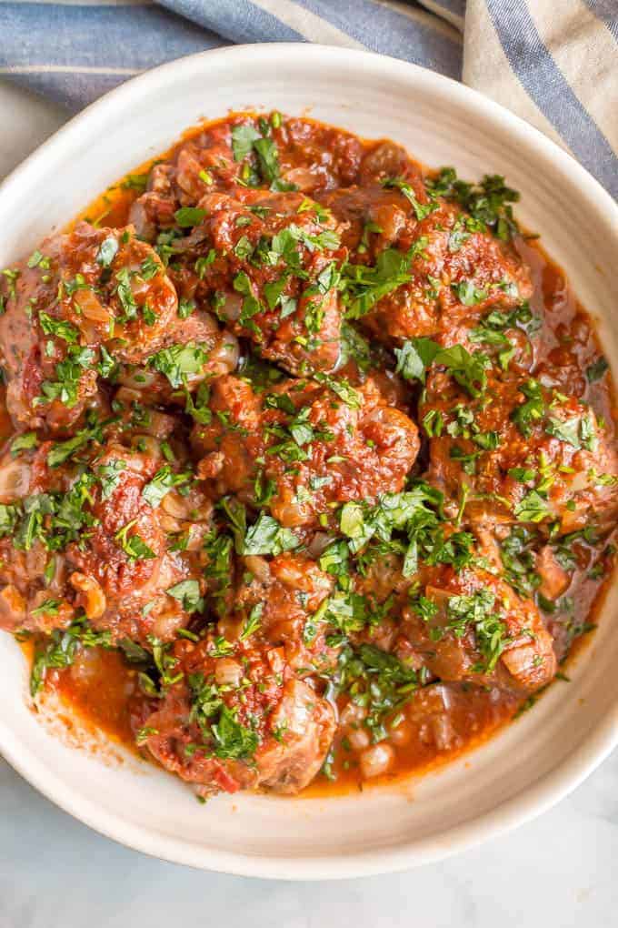 Slow cooker bistro chicken thighs are easy to prep and cook all day in a delicious, rich red wine and tomato sauce. Serve over mashed potatoes, rice or pasta for a yummy dinner! #slowcooker #chickendinner #slowcookerchicken | www.familyfoodonthetable