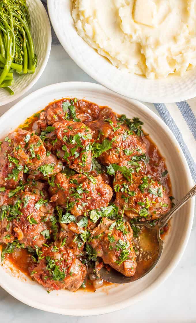 Slow cooker bistro chicken thighs are easy to prep and cook all day in a delicious, rich red wine and tomato sauce. Serve over mashed potatoes, rice or pasta for a yummy dinner! #slowcooker #chickendinner #slowcookerchicken | www.familyfoodonthetable