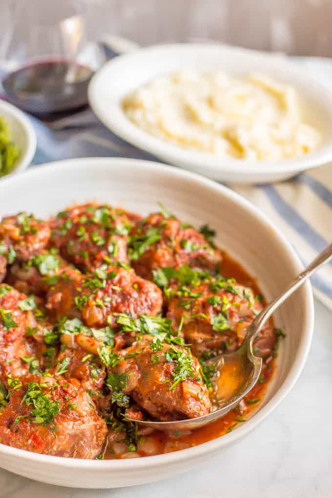 Slow cooker bistro chicken thighs are easy to prep and cook all day in a delicious, rich red wine and tomato sauce. Serve over mashed potatoes, rice or pasta for a yummy dinner! #slowcooker #chickendinner #slowcookerchicken | www.familyfoodonthetable