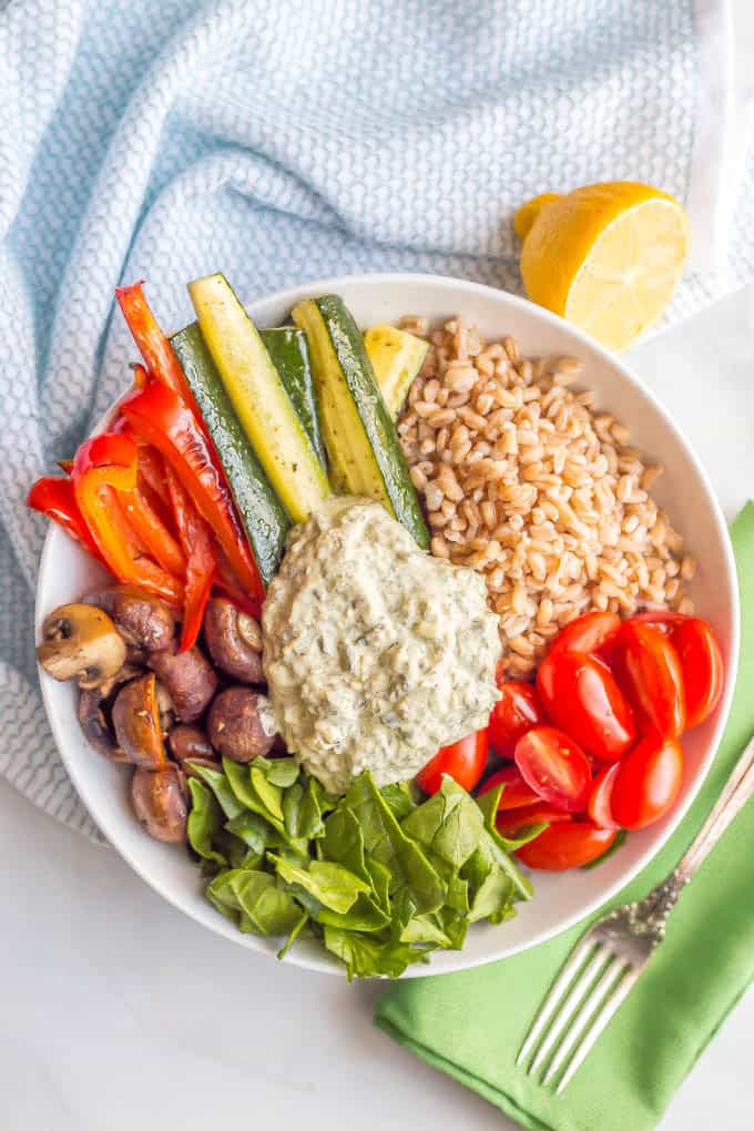 Farro and roasted vegetable grain bowl is a healthy vegetarian lunch or light dinner loaded with whole grains, roasted and fresh veggies and topped with a creamy spinach and kale dip. #grainbowl #vegetarian #lunchbowl | www.familyfoodonthetable.com