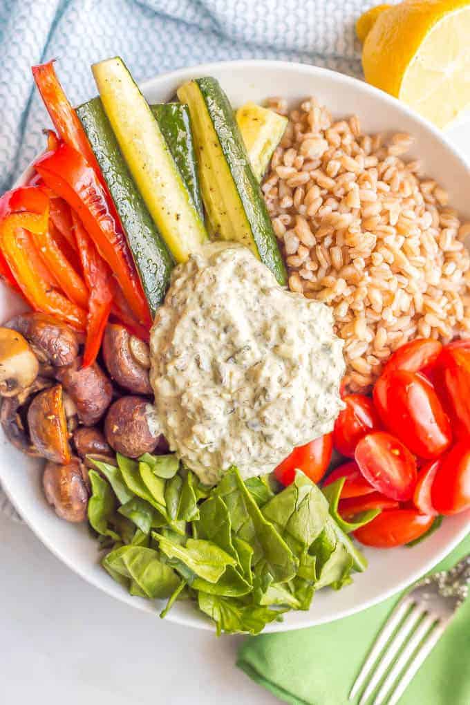 Farro and roasted vegetable grain bowl is a healthy vegetarian lunch or light dinner loaded with whole grains, roasted and fresh veggies and topped with a creamy spinach and kale dip. #grainbowl #vegetarian #lunchbowl | www.familyfoodonthetable.com