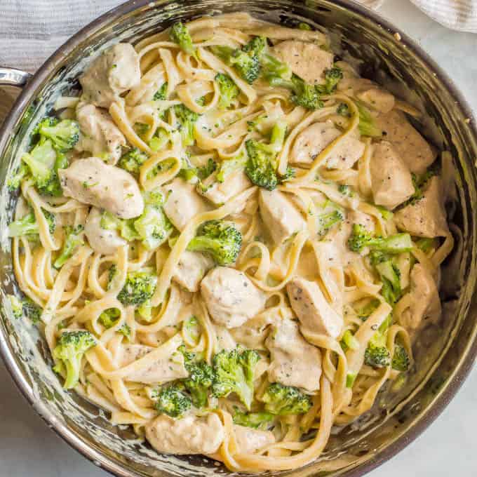 Healthy chicken Alfredo with broccoli mixed together in a large saute pan
