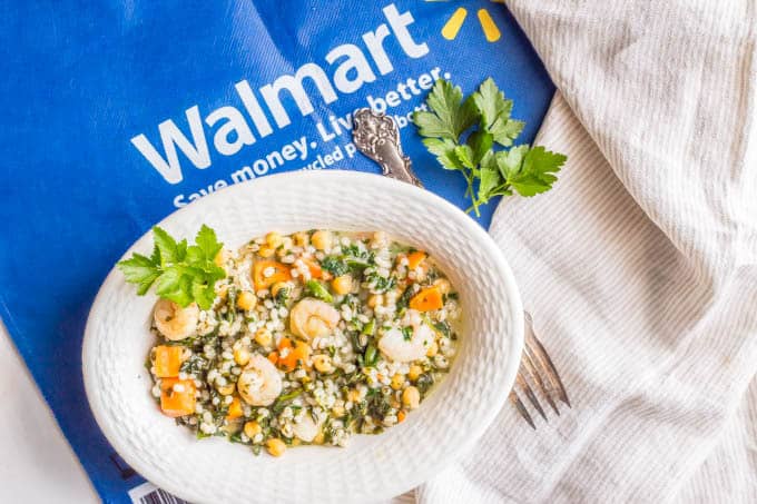 Lemon herb shrimp and veggies with barley in a serving dish with a Walmart bag underneath