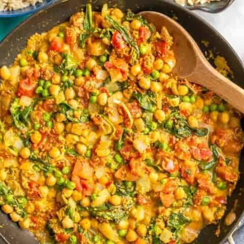 This quick and easy vegetarian curry is loaded with chickpeas, spinach, green peas and plenty of warm spices for a bright, beautiful and flavorful dinner! #curryrecipe #vegetariancurry #easyvegetarian #quickeasydinner | www.familyfoodonthetable.com