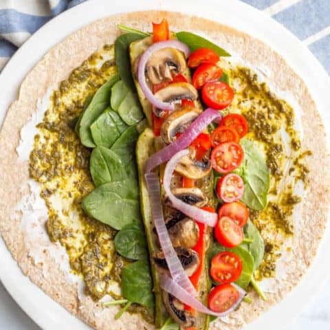 This roasted veggie wrap with pesto and goat cheese is the ultimate in lunchtime satisfaction! This vegetarian wrap can be prepped ahead and reheated and can also be customized to include your favorite vegetables! #veggiewrap #veggielunch #healthylunch | www.familyfoodonthetable.com