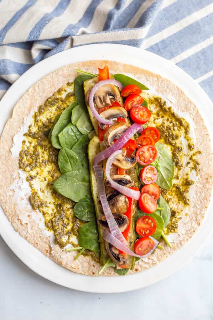 This roasted veggie wrap with pesto and goat cheese is the ultimate in lunchtime satisfaction! This vegetarian wrap can be prepped ahead and reheated and can also be customized to include your favorite vegetables! #veggiewrap #veggielunch #healthylunch | www.familyfoodonthetable.com