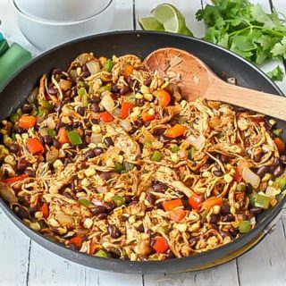 Southwest chicken skillet dinner prepared in pan with a wooden spoon
