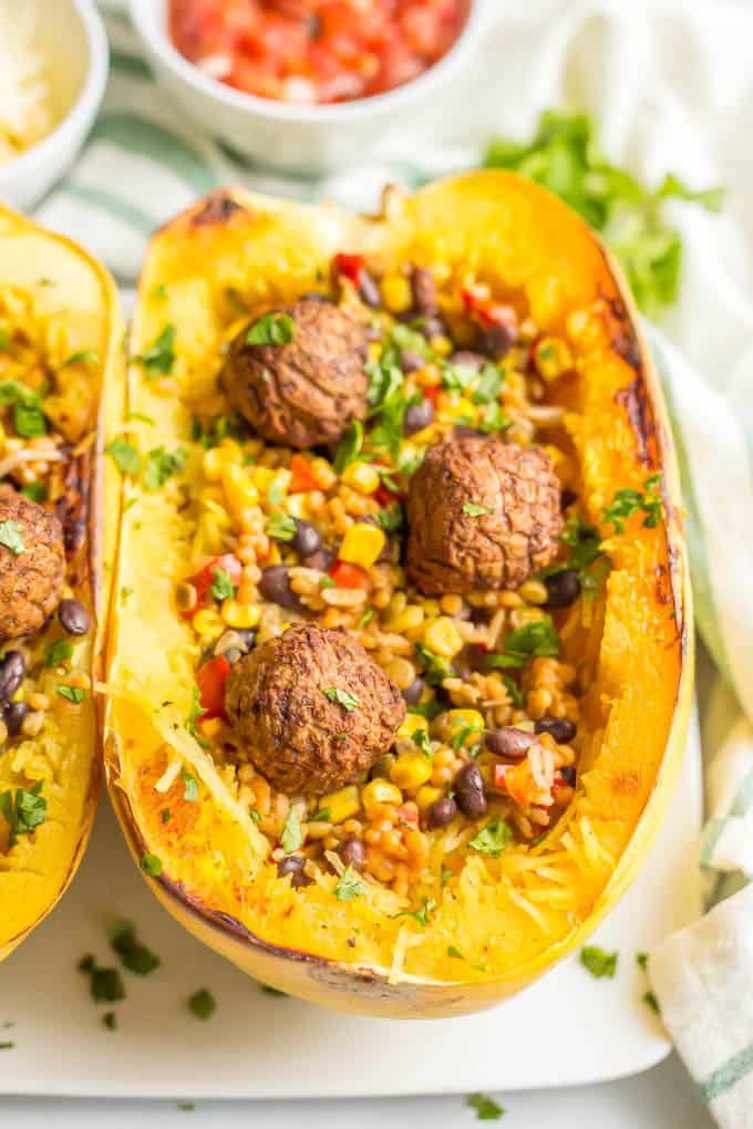 Close up side angle of Southwest vegetarian stuffed spaghetti squash with meatballs on top and cilantro sprinkled over everything