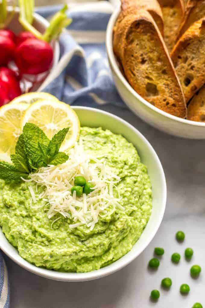 This healthy pea dip is a quick and easy recipe that makes for a pretty appetizer at parties. This creamy dip features ricotta and Parmesan cheese and goes great with baguette slices, water crackers or fresh veggies. #healthyappetizer #veggieappetizer #greenfood #peas | www.familyfoodonthetable.com