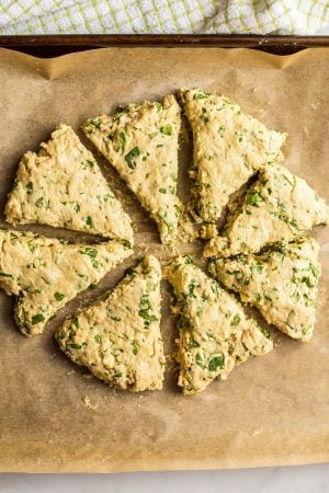 Whole wheat spinach cheddar scones on a baking sheet lined with parchment paper before being baked