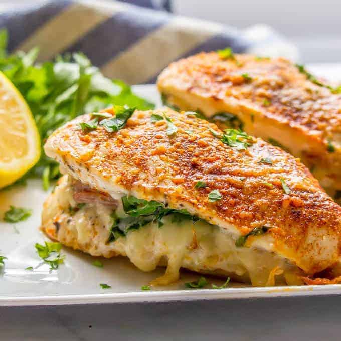 Close-up photo of chicken breasts stuffed with prosciutto, spinach and mozzarella cheese sprinkled with parsley