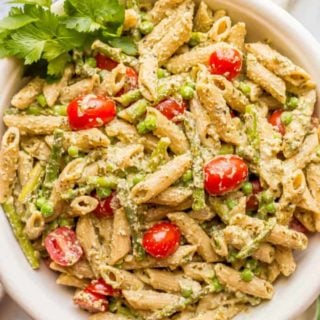 This warm and creamy pesto pasta with spring vegetables is an easy one-pot pasta recipe with peas, asparagus, and ricotta and Parmesan cheeses. It’s great as a light vegetarian meal or as a side dish at dinner! #pestopasta #vegetarianpasta #springpasta | www.familyfoodonthetable.com