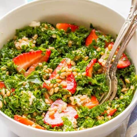 Farro, kale and strawberry salad with goat cheese is a delicious combination with bright, fresh flavors and tons of great texture. It’s perfect for a light lunch or as a side salad with dinner. #farrosalad #kalesalad #veggiesalad #healthysalad | www.familyfoodonthetable.com