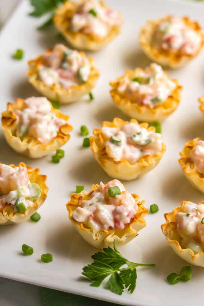 Creamy shrimp salad in mini phyllo cups being served on a white plate
