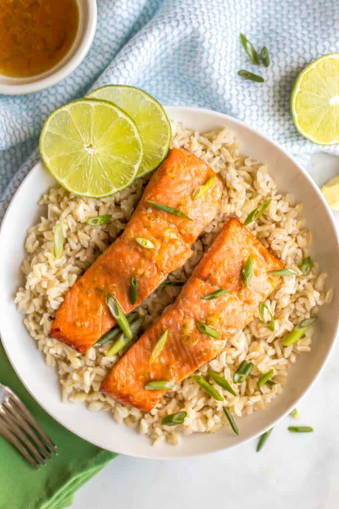 Honey lime roasted salmon on a bed of brown rice with scallions and lime slices