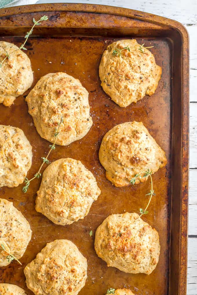 Parmesan herb drop biscuits on baking tray with thyme scattered about