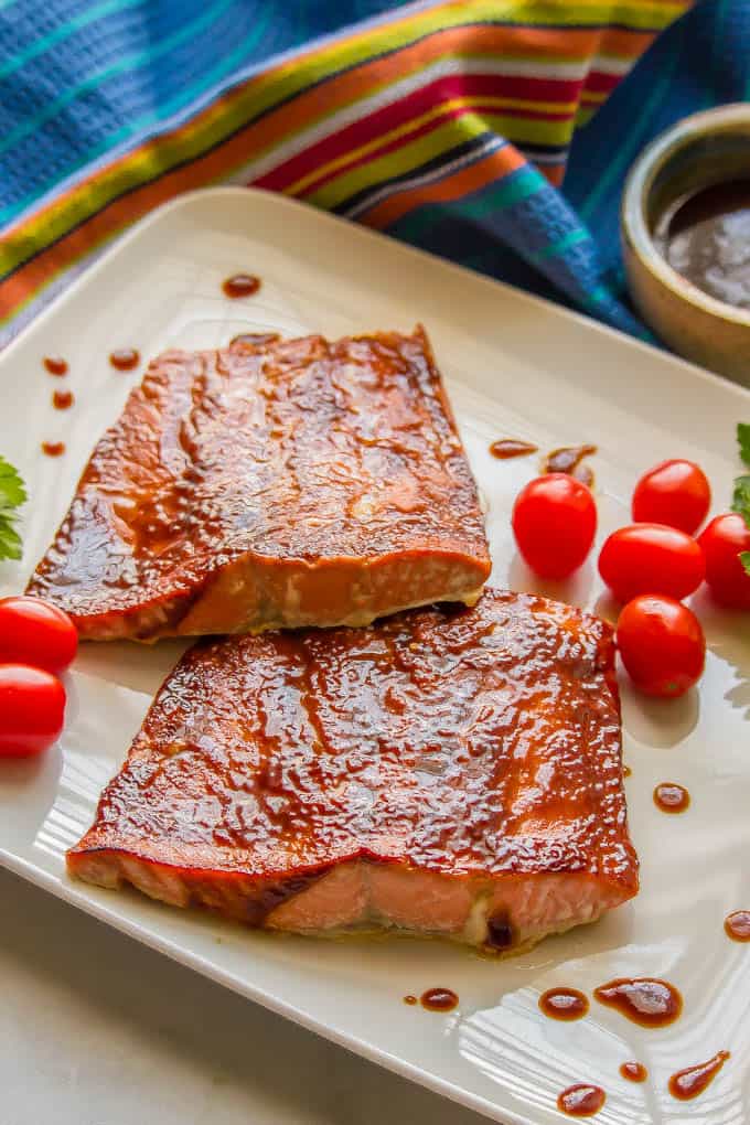 Easy BBQ salmon after being oven roasted on a white plate with spots of BBQ sauce