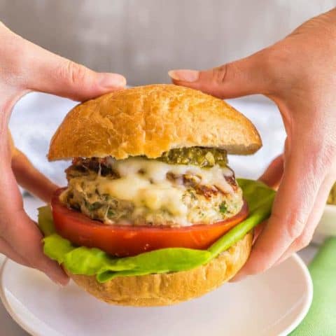 Chicken spinach burgers have just 5 ingredients and are full of cheesy shredded mozzarella, chopped fresh spinach and rich flavor from the touch of pesto. Top with extra mozzarella and pesto and serve on buns or in a lettuce wrap for a delicious, healthy burger! #chickenburger #groundchicken #healthyburger | www.familyfoodonthetable.com