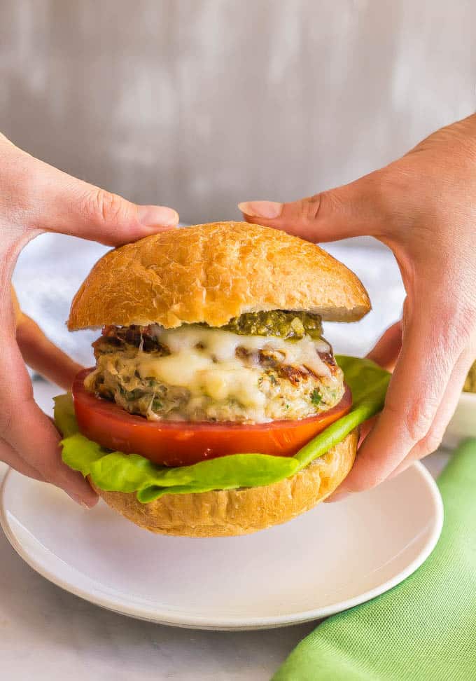 Chicken spinach burgers have just 5 ingredients and are full of cheesy shredded mozzarella, chopped fresh spinach and rich flavor from the touch of pesto. Top with extra mozzarella and pesto and serve on buns or in a lettuce wrap for a delicious, healthy burger! #chickenburger #groundchicken #healthyburger | www.familyfoodonthetable.com