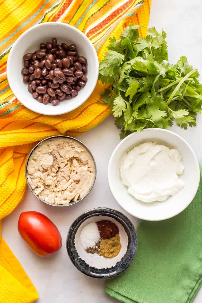 Ingredients spread out for southwest tuna salad with colorful napkins nearby